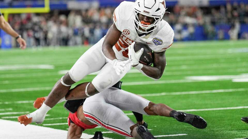 Texas running back Quintrevion Wisner (26) is knocked out of bounds but an Ohio State defender during the second half of a College Football Playoff semifinal game at the Goodyear Cotton Bowl, Friday, Jan. 10, 2025, in Arlington.