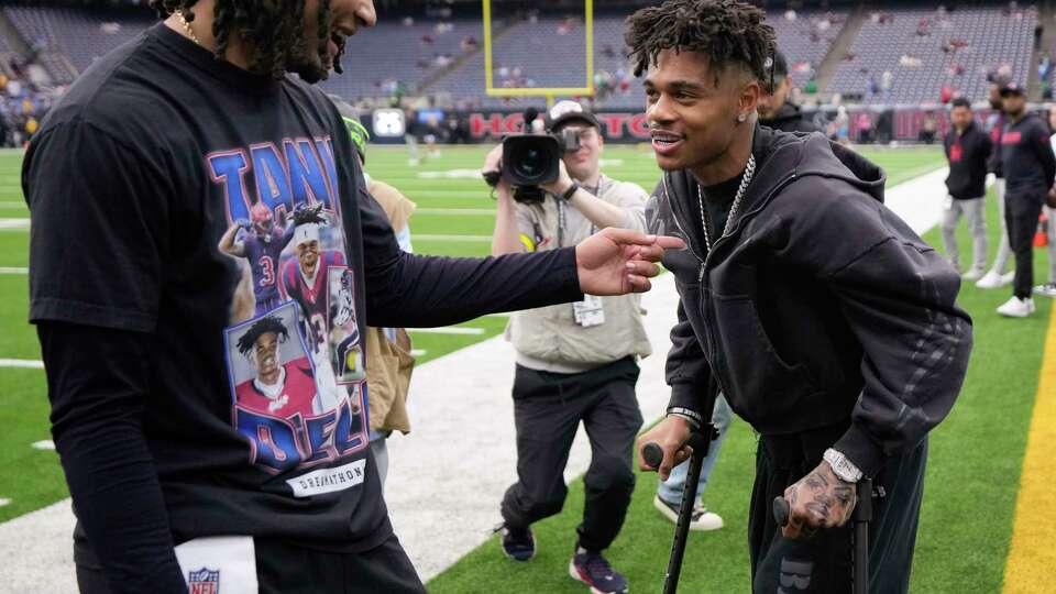 Houston Texans quarterback C.J. Stroud, left, talks to injured wide receiver Tank Dell on the sidelines before an AFC Wild Card football game against the Los Angeles Chargers, Saturday, Jan. 11, 2025, in Houston. Dell injured his knee on Dec. 21 making a touchdown catch against the Kansas City Chiefs.