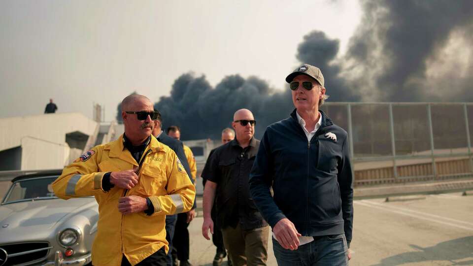 California Governor Gavin Newsom, right, tours the downtown business district of Pacific Palisades as the Palisades Fire continues to burn on Jan. 8, 2025, in Los Angeles. Fueled by intense Santa Ana Winds, the Palisades Fire has grown to over 2,900 acres and 30,000 people have been ordered to evacuate while a second major fire continues to burn near Eaton Canyon in Altadena.