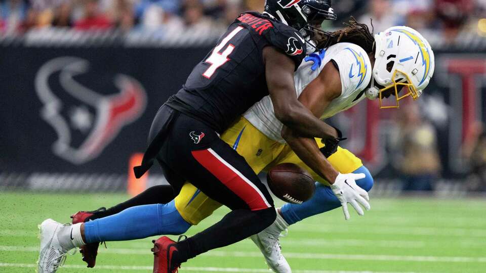 Houston Texans cornerback Kamari Lassiter (4) breaks up a pass intended for Los Angeles Chargers wide receiver Quentin Johnston (1) during the first half of an AFC Wild Card playoff football game, Saturday, Jan. 11, 2025, in Houston.