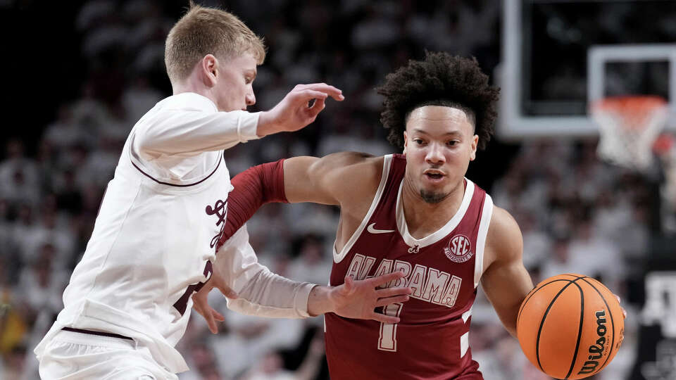 Alabama guard Mark Sears (1) drives around Texas A&M guard Hayden Hefner, left, for a basket during the second half of an NCAA college basketball game Saturday, Jan. 11, 2025, in College Station, Texas. (AP Photo/Sam Craft)