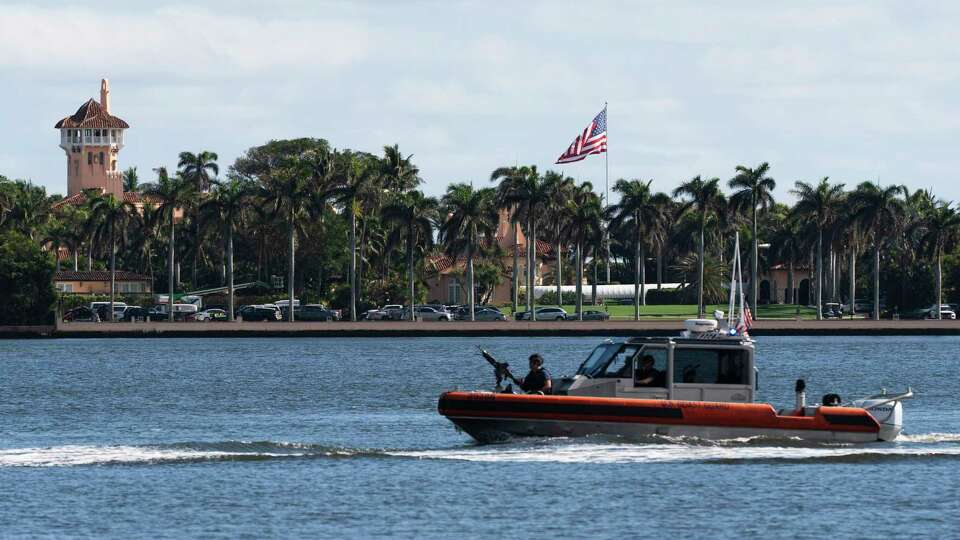 The U.S. flag is shown at the Mar-a-Lago compound in Palm Beach, Fla., while a U.S. Coast Guard boat patrols around the vicinity, Monday, Jan. 13, 2025. U.S. flags at President-elect Donald Trump's private Mar-a-Lago club are back to flying at full height. Flags are supposed to fly at half-staff through the end of January out of respect for former President Jimmy Carter, who died Dec. 29. (AP Photo/Manuel Balce Ceneta)