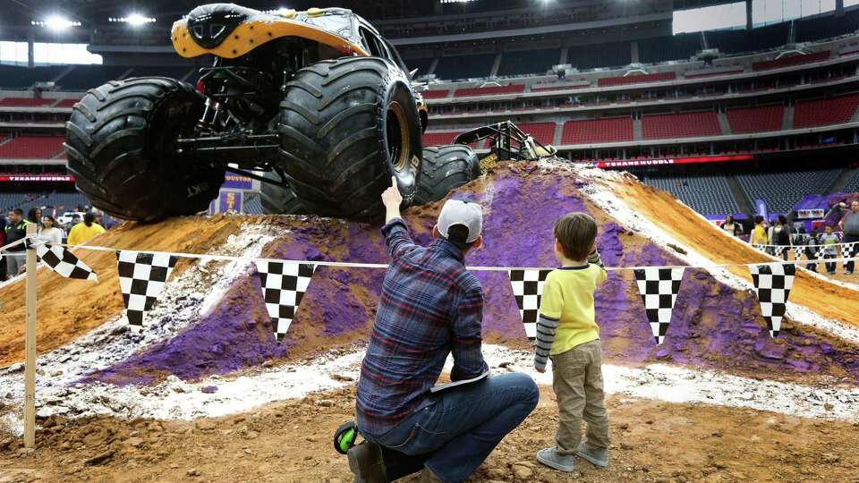 Druett Lee, left, talks with his sone Xavier, 4, about the 'Monster Mutt' monster truck at the Pit Party for Monster Jam at NRG Stadium Sunday, Jan. 24, 2016, in Houston. The show will be Xavier's first, and Druett's first in 25 years.