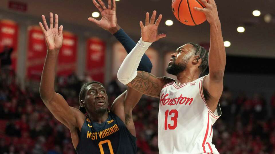 Houston forward J'Wan Roberts (13) goes up against West Virginia center Eduardo Andre (0) during the first half of a Big 12 Conference NCAA basketball game, Wednesday, Jan. 15, 2025, in Houston.