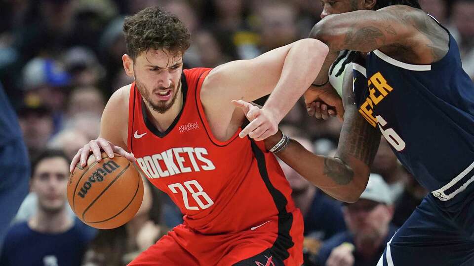 Houston Rockets center Alperen Sengun, left, drives to the basket as Denver Nuggets center DeAndre Jordan defends in the first half of an NBA basketball game Wednesday, Jan. 15, 2025, in Denver. (AP Photo/David Zalubowski)