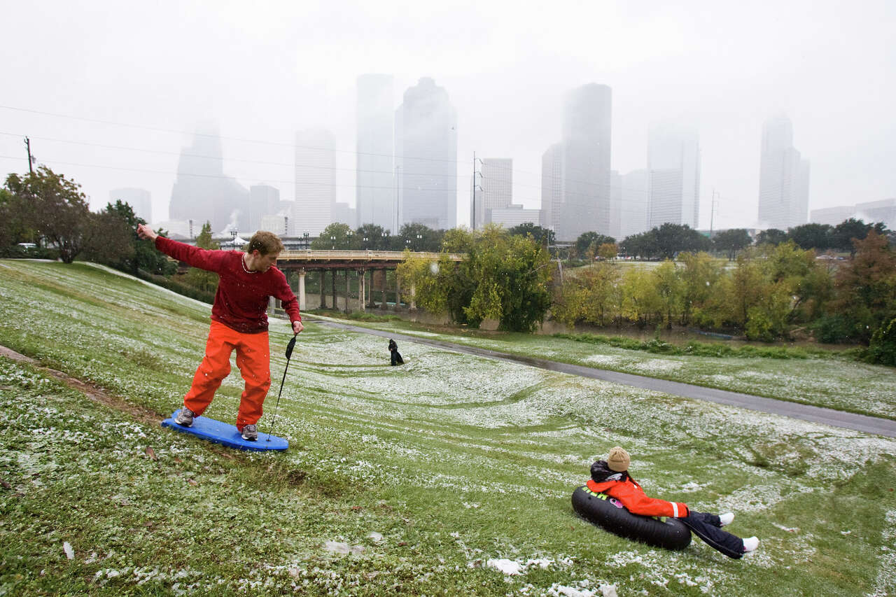 Chris Lewis (cq), of Houston, left, rides a boogie board turned snow sled down a snow slicked hill with Lauren Lewis (cq), of Houston, Friday, Dec. 4, 2009, at Eleanor Tinsley Park in Houston. ( Nick de la Torre / Chronicle )