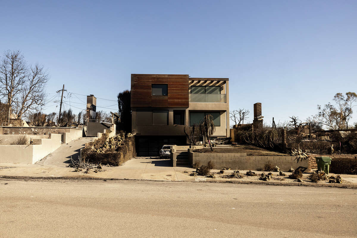 A house remains standing next to homes burnt down by the Palisades Fire in Los Angeles, Calif.