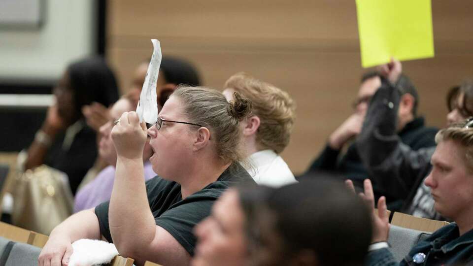 Community members hold signs and cheer as the Cypress Fairbanks ISD school board weighs a purposed parent policy, which would require staff to 'out' transgender students to their parents, during a district meeting, Thursday, Jan. 16, 2025, in Cypress.