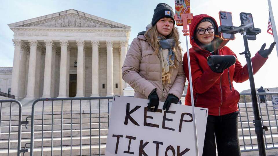 FILE - Sarah Baus, left, of Charleston, S.C., and Tiffany Cianci, who says she is a 'long-form educational content creator,' livestream to TikTok outside the Supreme Court, on Jan. 10, 2025, in Washington.