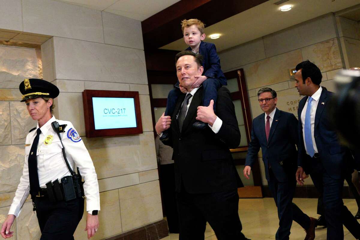 Elon Musk with his son on shoulders and Vivek Ramaswamy walk on Capitol Hill accompanied by House Speaker Mike Johnson (R-LA) to meet with members of Congress on Capitol Hill in Washington, D.C., on Dec. 5, 2024.