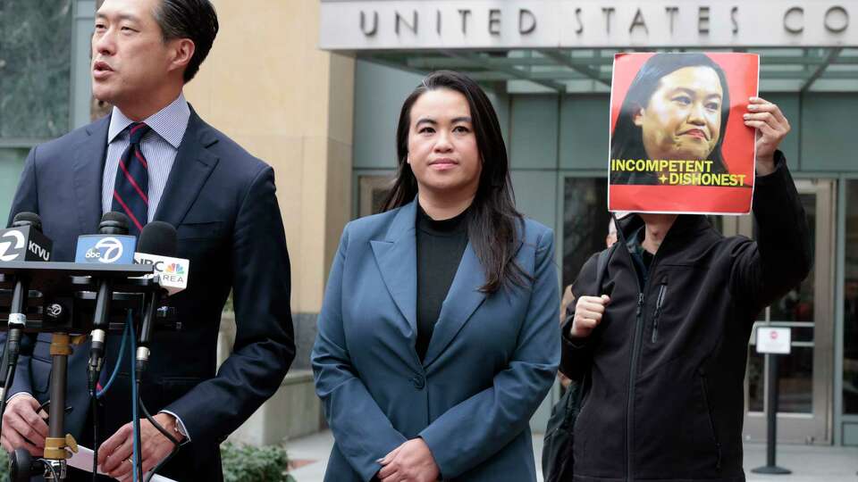 Sheng Thao stands next to her lawyer Jeff Tsai outside the United States District Court after a hearing in Oakland, Calif., on Friday, Jan. 17, 2025. Next to them, Tuan Ngo, founder of Asians Unite, protests. The former mayor of Oakland was criminally indicted by a federal grand jury after an FBI corruption investigation, which centered on City Hall and a powerful family that operates the city’s curbside recycling program, a source familiar with the matter told the Chronicle.