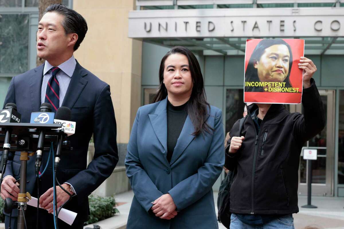 Sheng Thao stands next to her lawyer Jeff Tsai outside the United States District Court after a hearing in Oakland, Calif., on Friday, Jan. 17, 2025. Next to them, Tuan Ngo, founder of Asians Unite, protests. The former mayor of Oakland was criminally indicted by a federal grand jury after an FBI corruption investigation, which centered on City Hall and a powerful family that operates the city’s curbside recycling program, a source familiar with the matter told the Chronicle.