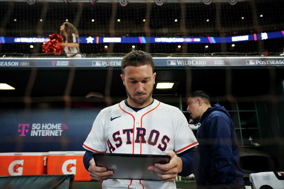 Alex Bregman of the Houston Astros checks the iPad in the dugout prior to Game 1 of the Wild Card Series between the Detroit Tigers and the Houston Astros at Minute Maid Park on Tuesday, October 1, 2024 in Houston, Texas.