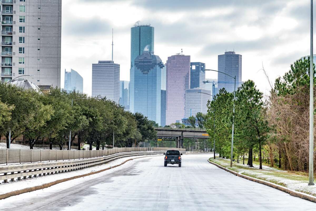 Vehicles navigate the snow and ice on Memorial Drive into downtown Houston as a storm unleashes record cold temperatures in southeast Texas. A storm is likely to grip Houston starting Monday night.