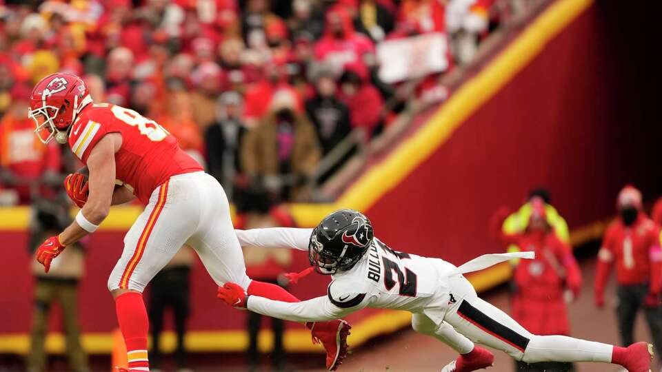 Houston Texans safety Calen Bullock (21) tackles Kansas City Chiefs tight end Travis Kelce (87) after a big catch and run during the first half of an AFC Divisional playoff football game, Saturday, Jan. 18, 2025, in Kansas City, Mo.