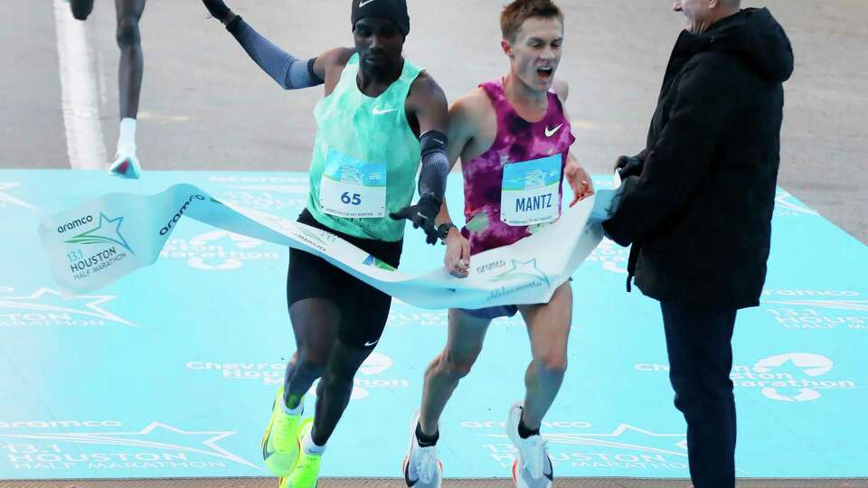 Addisu Goben, left, and Conner Mantz, right, battle for first place as they cross the finish line in the half-marathon aduring the Chevron Houston Marathon Sunday, Jan. 19, 2025 in Houston.