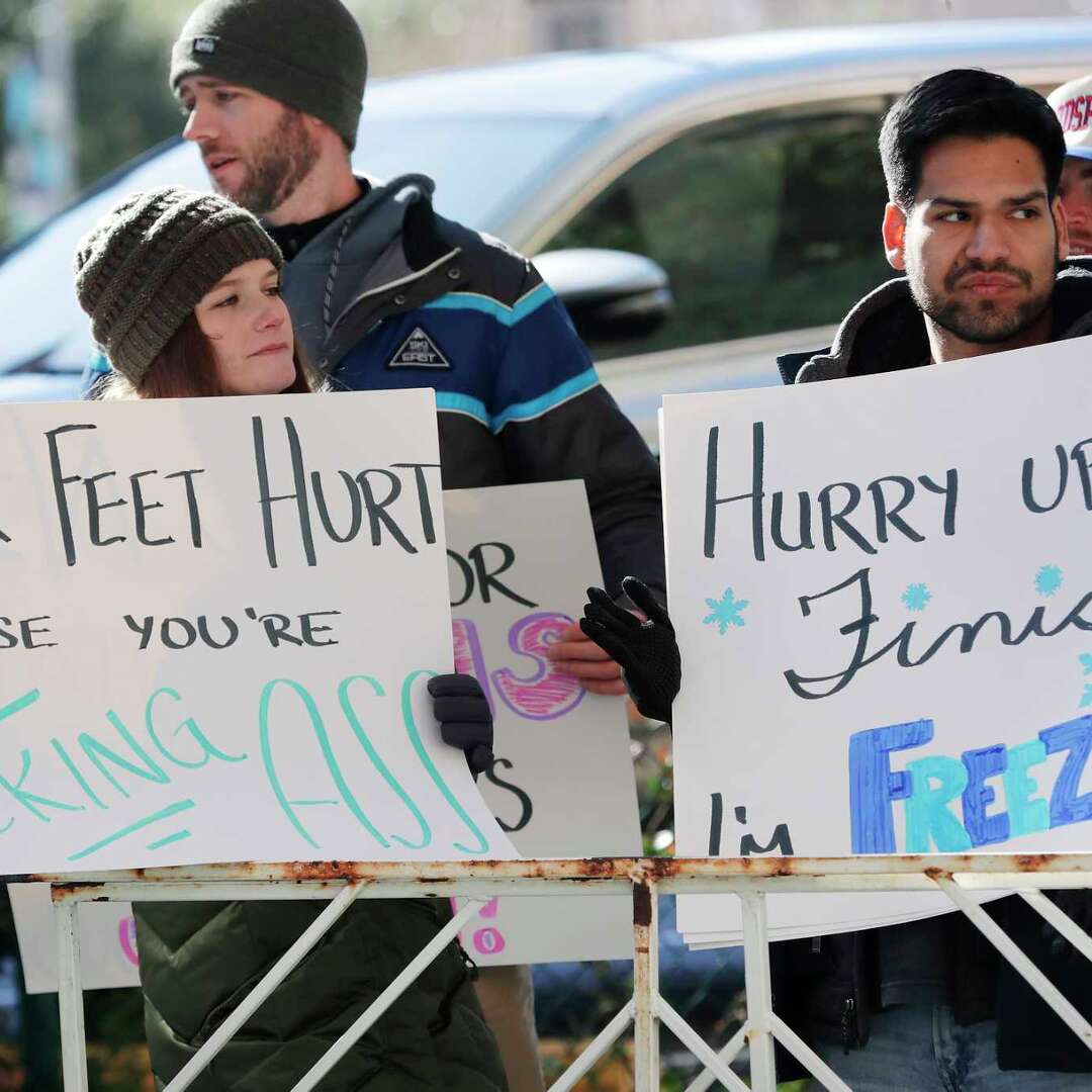 Spectators hold up signs near the finish line during the Chevron Houston Marathon Sunday, Jan. 19, 2025 in Houston.