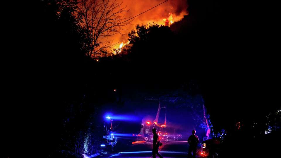 Firefighters prepare for structural defense as the Palisades Fire burns on a hilltop in the Mandeville Canyon neighborhood of Los Angeles,, Calif., Friday, Jan. 10, 2025.