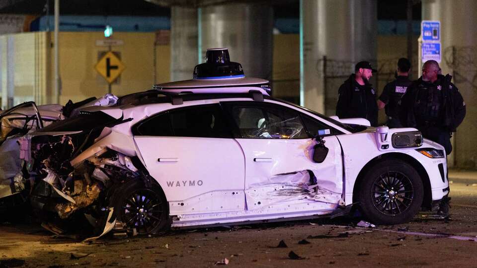 A wrecked Waymo car rests behind a police line at the scene of a crash at Sixth and Harrison Streets in San Francisco on Sunday, Jan. 19, 2025.