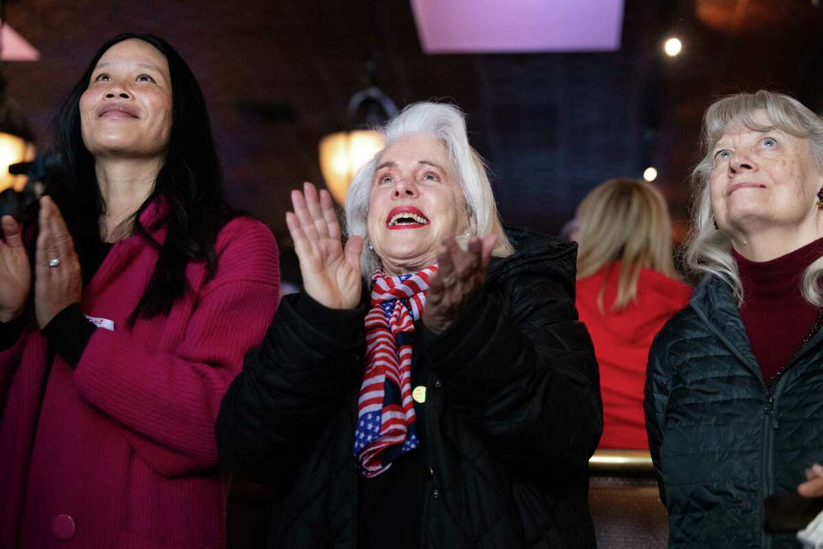 Lina Pritchard, center, claps after the national anthem at a GOP inauguration watch party at Harry's Bar in San Francisco on Monday, Jan. 20, 2025. Donald Trump is being sworn in as the 47th President of the United States.