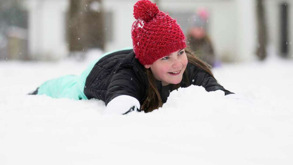 Layton Patterson plays in snow in her front yard during an icy winter storm, Tuesday, Jan. 21, 2025, in Kingwood.