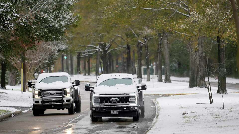 Snow covered vehicles move along Cypresswood Dr. near Champion Forest Dr. Tuesday, Jan. 21, 2025, in Spring.