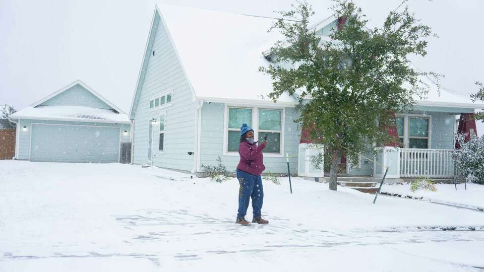 Chuyone McGuire-Ford films the snow around her house in the Balmoral neighborhood in Atascocita, TX on Tuesday January 21, 2025.