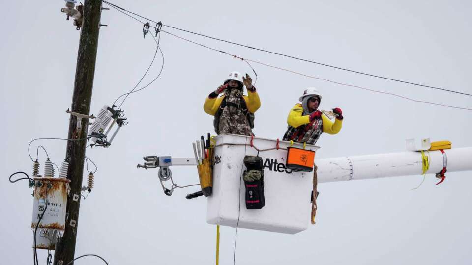 Electrical lineman work on power lines during an icy winter storm on Tuesday, Jan. 21, 2025 in Galveston.