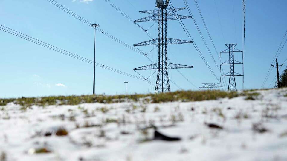 Transmission lines with snow on the ground is shown along the North Sam Houston Parkway near SH249 Tuesday, Jan. 21, 2025, in Houston.