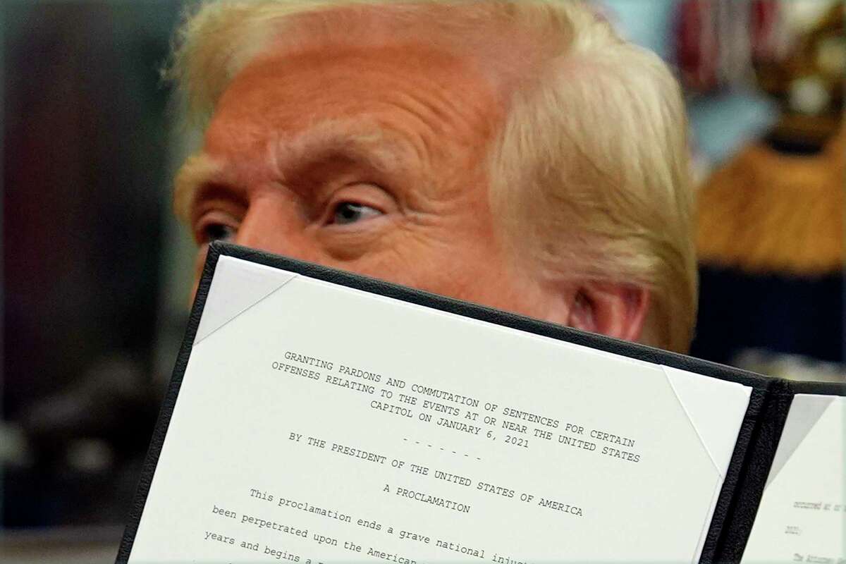 President Donald Trump signs an executive order pardoning about 1,500 defendants charged in the Jan. 6 attack on the U.s> Capitol in the Oval Office of the White House, Monday, Jan. 20, 2025, in Washington. (AP Photo/Evan Vucci)