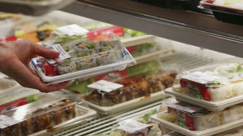 Shoppers select prepared food items from the deli at Suruki Supermarket on Thursday, August 12, 2021 in San Mateo,, Calif.