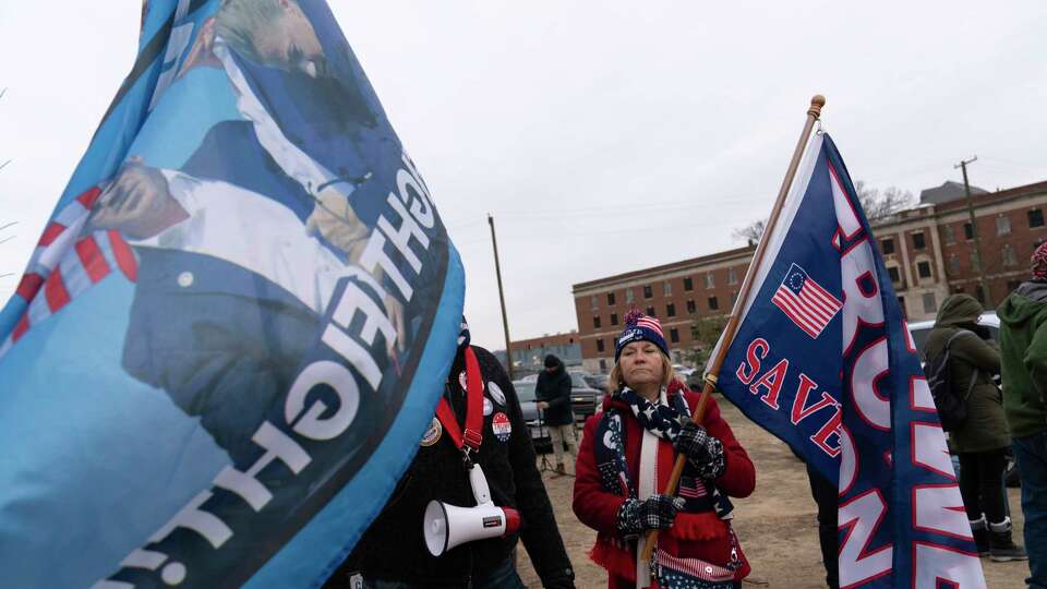 Supporters of President Donald Trump stand with their flags in support of people convicted for their part in the Jan. 6 riot at the U.S. Capitol at the DC Central Detention Facility in Washington, Tuesday, Jan. 21, 2025.