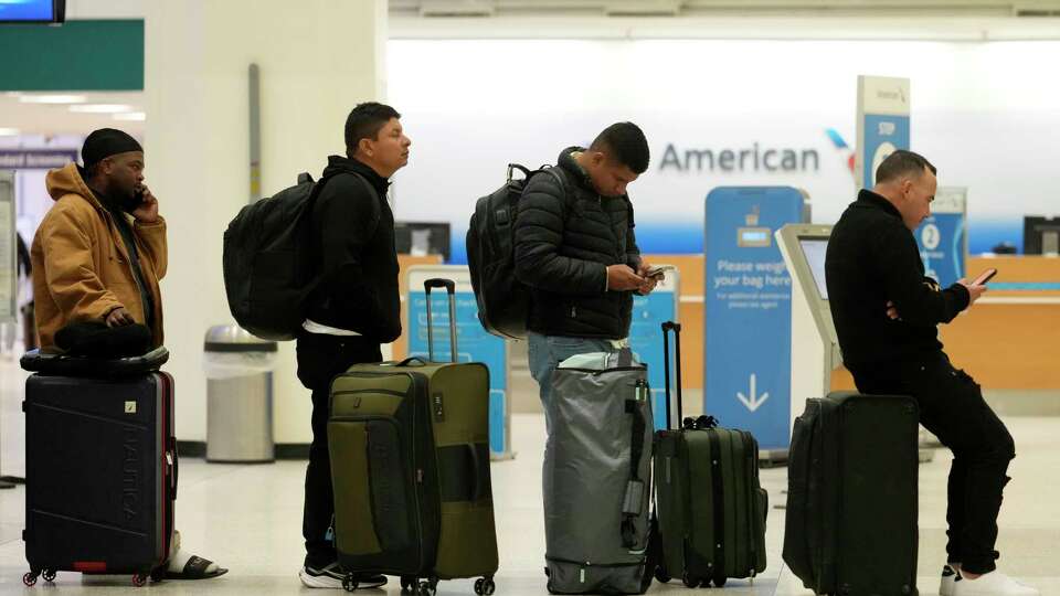 People are shown waiting in line at the American ticket counter in Terminal A at George Bush Intercontinental Airport Wednesday, Jan. 22, 2025, in Houston. Both Houston airports reopened Wednesday after being closed on Tuesday due to the winter storm.