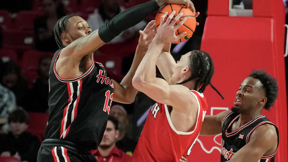 Houston forward J'Wan Roberts (13) blocks a shot by Utah forward Keanu Dawes (8) during the second half of an NCAA men’s college basketball game, Wednesday, Jan. 22, 2025, in Houston.