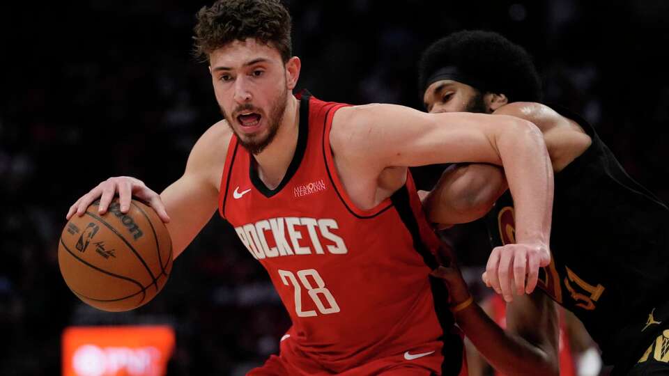 Houston Rockets center Alperen Sengun (28) controls the ball against Cleveland Cavaliers center Jarrett Allen (31) during the first half of an NBA basketball game in Houston, Wednesday, Jan. 22, 2025. (AP Photo/Ashley Landis)