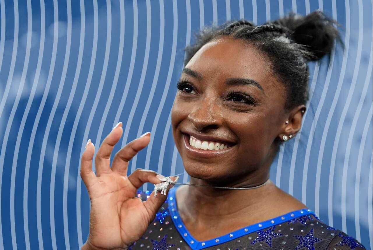 Simone Biles shows off her GOAT necklace at Olympics in Paris.