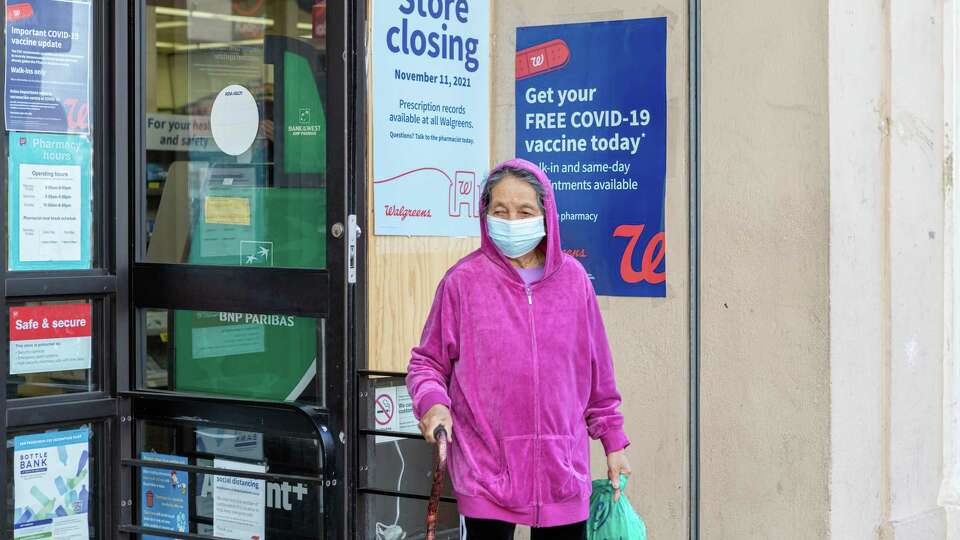 A woman, who did not want to be named, leaves a Walgreens store located at 4645 Mission Street on Friday, October 22, 2021, in San Francisco, Calif. The store is scheduled to close on November 11.