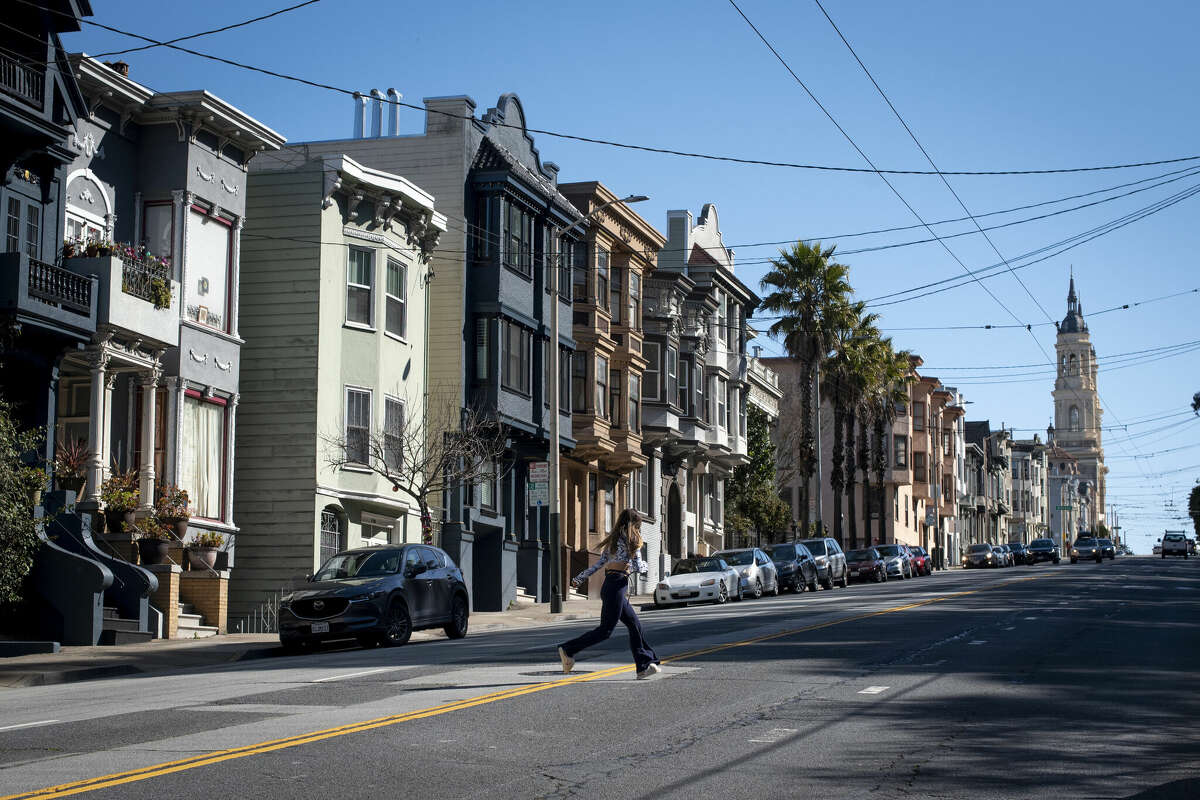 FILE - A pedestrian crosses a street in the Richmond District on Friday, March 12, 2021. 