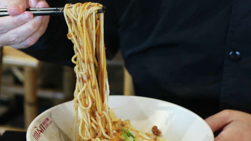 A patron stretches out the chengdu zajiang noodles at Mian in Santa Clara.