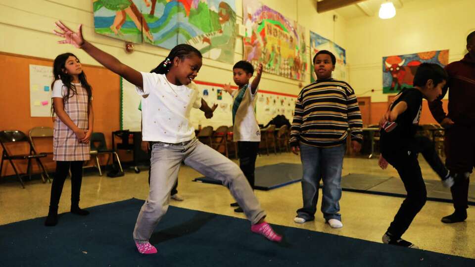 Ava Walker (white shirt), 8, a 4th grader, performs a cartwheel with Prescott Circus Theatre at Prescott Elementary in Oakland, Calif. on Friday, January 10, 2025. Prescott Circus Theatre is a program that offers an after school circus arts class with 3-5th grade students. Prescott Circus Theatre, a 40-year-old nonprofit run out of Prescott Elementary School in West Oakland, also offers summer camps and runs after-school programs at several OUSD schools. The trickle-down effect of Oakland’s wide-spanning budget cuts should be devastating for numerous organizations throughout the city, but they’ll be particularly brutal for local arts nonprofits — almost all of which must now try to chart paths forward without any city grants.