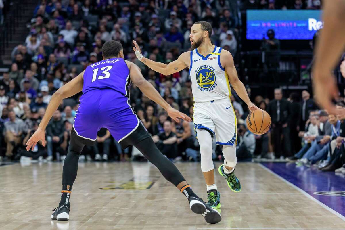 Golden State Warriors guard Stephen Curry (30) dribbles upcourt with Sacramento Kings forward Keegan Murray (13) on defense during the second half of an NBA basketball game Wednesday, Jan. 22, 2025, in Sacramento, Calif.