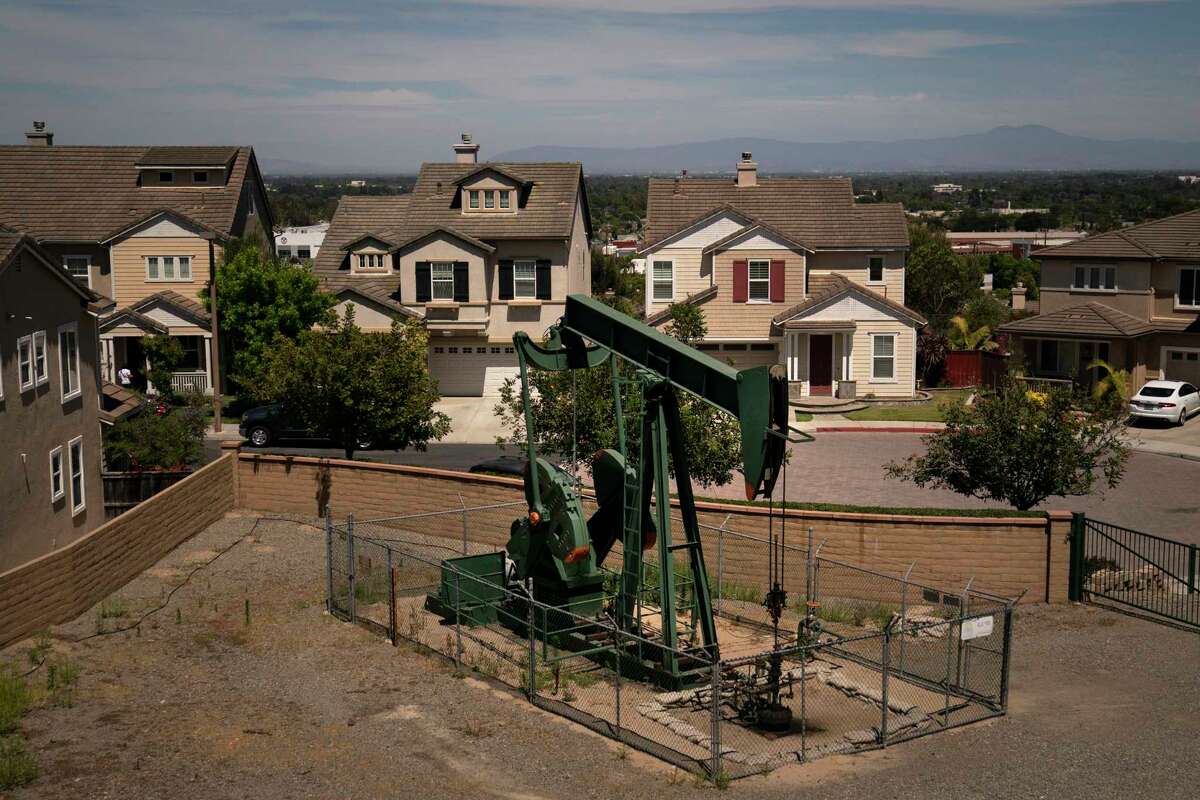 A pump jack extracts oil at a drilling site next to homes on June 9, 2021, in Signal Hill, Calif. A California legislative committee has blocked a bill that would have made oil companies liable for the health problems of people who live close to oil wells. It's among dozens of bills that did not survive the legislature's suspense file hearings.