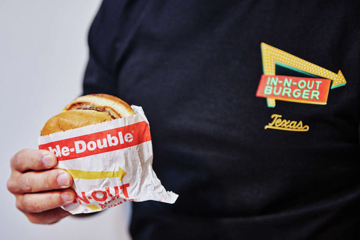 Spencer Farrar holding an In-N-Out burger while wearing an In-N-Out t-shirt inside his apartment in New York City, on Monday, Jan. 20, 2025. 