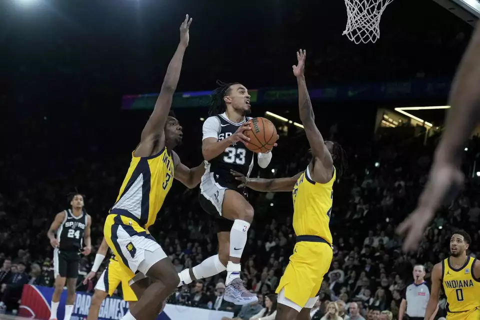 San Antonio Spurs guard Tre Jones (33) shoots between Indiana Pacers center Thomas Bryant, left, and forward Aaron Nesmith (23) during the second half of a Paris Games 2025 NBA basketball game in Paris, Saturday, Jan. 25, 2025. (AP Photo/Thibault Camus)