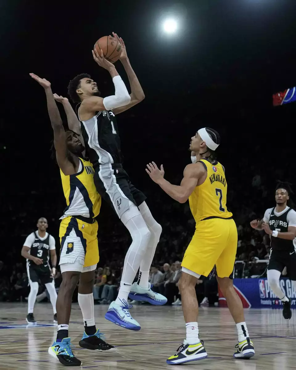 San Antonio Spurs center Victor Wembanyama (1) shoots over Indiana Pacers guard Andrew Nembhard (2) during the second half of a Paris Games 2025 NBA basketball game in Paris, Saturday, Jan. 25, 2025. (AP Photo/Thibault Camus)