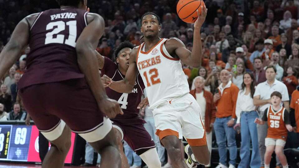 Texas guard Tramon Mark (12) drives to the basket abasing Texas A&M forward Pharrel Payne (21) for the winning basket during the second half of an NCAA college basketball game in Austin, Texas, Saturday, Jan. 25, 2025. (AP Photo/Eric Gay)