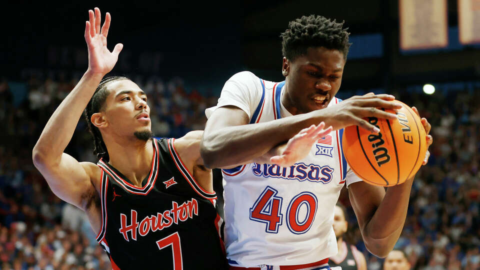 Kansas forward Flory Bidunga (40) grabs a rebound as Houston guard Milos Uzan (7) defends during the first half of an NCAA college basketball game, Saturday, Jan. 25, 2025, in Lawrence, Kan. (AP Photo/Colin E. Braley)