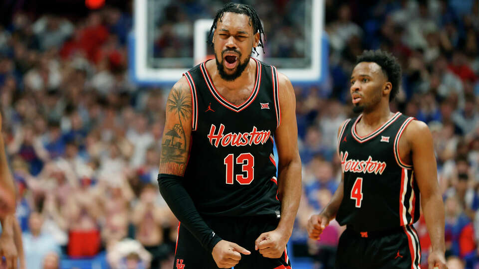 Houston forward J'Wan Roberts (13) reacts after scoring the go-ahead basket next to guard L.J. Cryer (4) during double overtime against Kansas in an NCAA college basketball game, Saturday, Jan. 25, 2025, in Lawrence, Kan. (AP Photo/Colin E. Braley)