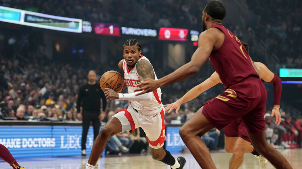 Houston Rockets guard Jalen Green, left, drives past Cleveland Cavaliers forward Evan Mobley, right, in the first half of an NBA basketball game, Saturday, Jan. 25, 2025, in Cleveland. (AP Photo/Sue Ogrocki)