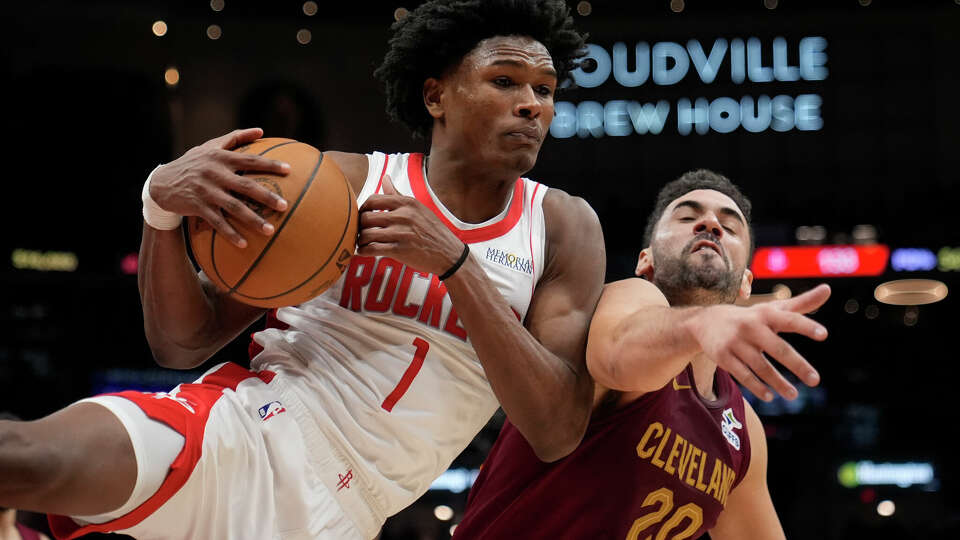 Houston Rockets forward Amen Thompson (1) comes down with a rebound in front of Cleveland Cavaliers forward Georges Niang (20) in the second half of an NBA basketball game, Saturday, Jan. 25, 2025, in Cleveland. (AP Photo/Sue Ogrocki)